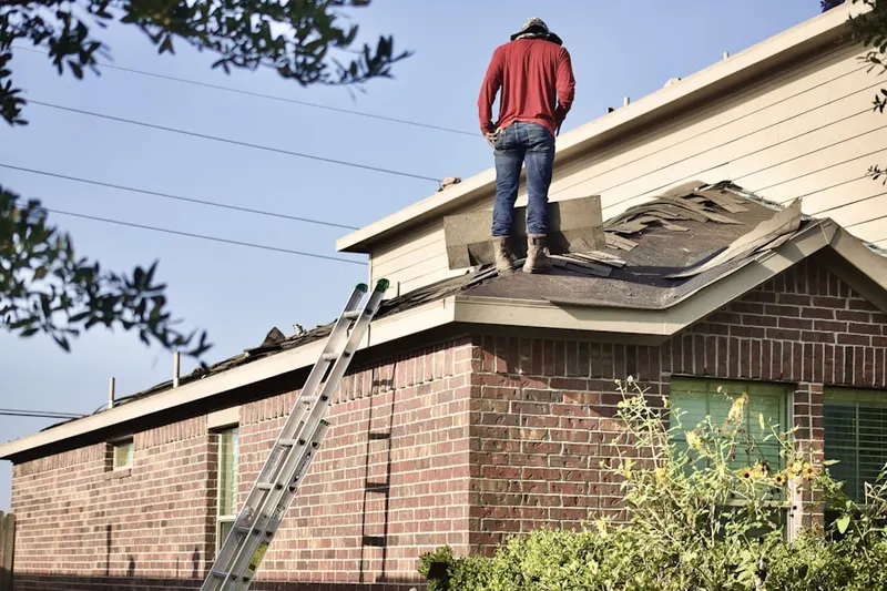 Professional roofer working on a residential roof in Galliano